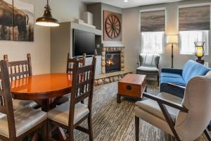 a living room with a dining room table and a fireplace at WorldMark Bison Ranch in Overgaard