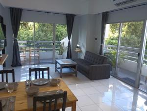 a living room with a couch and a table at Tree Top Beach Condo in Ban Pak Khlong Phe