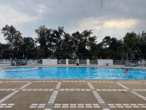 a large swimming pool with two people in the water at Tree Top Beach Condo in Ban Pak Khlong Phe