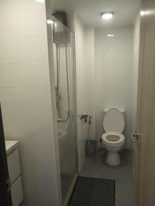 a bathroom with a toilet and a glass shower at Tree Top Beach Condo in Ban Pak Khlong Phe +9 photos