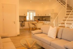 a living room with a white couch and a kitchen at Villa Aristidis Strates in Argyrádes