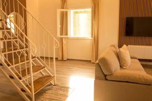 a living room with a staircase and a couch at Villa Aristidis Strates in Argyrádes