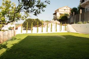 a yard with a white fence and green grass at Villa Aristidis Strates in Argyrádes