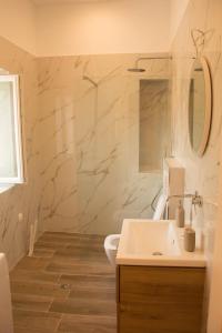 a bathroom with a white sink and a mirror at Villa Aristidis Strates in Argyrádes +29 photos