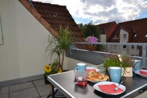 a table with a plate of food on a balcony at TESLA 10km Pure Nature in Beerfelde