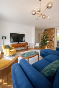 a living room with a blue couch and a table at La maison aux 5 nids in Saint-Cyr-sur-Loire