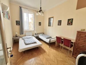 a room with two beds and a table and chairs at Bauhaus Astoria Hostel in Budapest