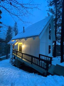 a small white house in the snow at night at Brentwood Haus in Lake Arrowhead