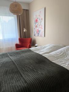 ein Schlafzimmer mit einem Bett und einem roten Stuhl in der Unterkunft Guesthouse Terkkari in Lahti