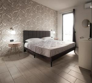 a bedroom with a bed and a wall with a leaf pattern at Hotel l'etoile de la ville in Montecatini Terme