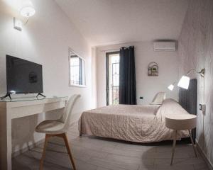 a bedroom with a bed and a desk and a chair at Hotel l'etoile de la ville in Montecatini Terme