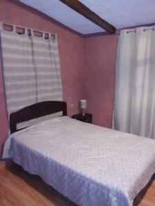 a bedroom with a white bed and a window at Casa Shaullo-Chalets in Los Baños del Inca