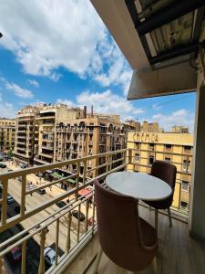 a balcony with a table and chairs and a view of a city at Calmaa Kairo in Cairo
