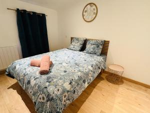 a bedroom with a bed with a clock on the wall at L'Emile Zola l 2 Chambres l Hypercentre in Castres