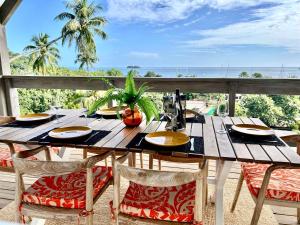 a wooden table with chairs on a balcony with the ocean at Villa Tiare in Bora Bora