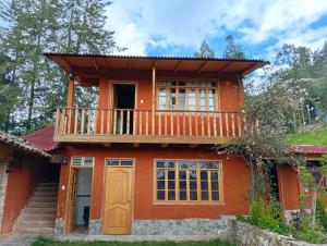 a house with a balcony on top of it at Casa Shaullo-Chalets in Los Baños del Inca