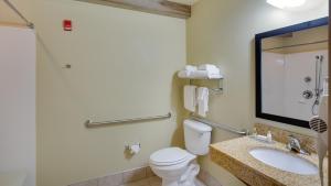 a bathroom with a toilet and a sink and a mirror at Cobblestone Inn & Suites - Brillion in Brillion +40 photos