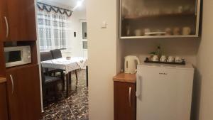 a kitchen with a small table and a refrigerator at Apartament Teilor in Râşnov