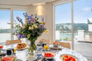 a table with a vase of flowers and food on it at No 21 The Salcombe in Salcombe +65 photos