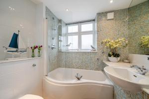 a bathroom with a bath tub and a sink at No 21 The Salcombe in Salcombe