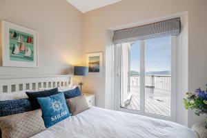 a bedroom with a bed and a large window at No 21 The Salcombe in Salcombe
