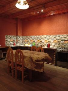 a kitchen with a table and chairs and a stone wall at Casa Shaullo-Chalets in Los Baños del Inca