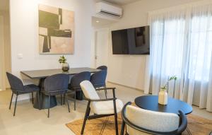 a dining room with a table and chairs and a tv at Villa Selina 8 - Etheras Properties in Kythira