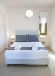a bedroom with a large white bed with blue pillows at Villa Selina 8 - Etheras Properties in Kythira +62 photos