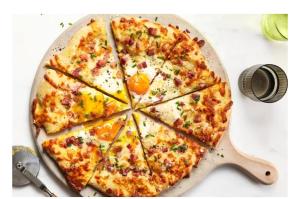 a pizza sitting on top of a pan on a table at L'étang du griffolet 2 in Ussac +6 photos
