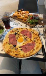 a pizza sitting on a table with an egg on it at L'étang du griffolet 2 in Ussac