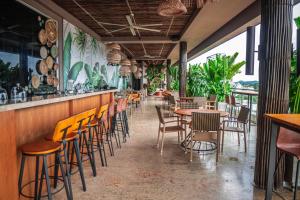 a restaurant with chairs and tables and a bar at GHL Hotel Monteria in Montería