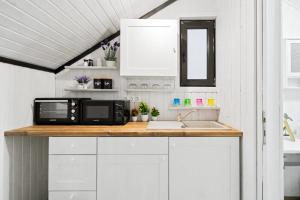 a kitchen counter with a microwave and a sink at The HIDE - Loftette in Ploieşti