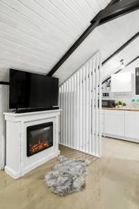 a living room with a fireplace with a tv on top at The HIDE - Loftette in Ploieşti