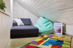 a living room with a couch and a rug at The HIDE - Loftette in Ploieşti +34 photos