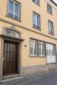 a building with a brown door and several windows at Altstadt City Loft in Würzburg