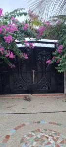 a black gate with pink flowers on it at Chez Aicha Ndangane in Ndangane