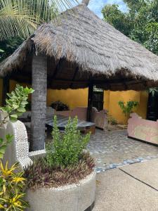 a hut with a table and chairs in a yard at Chez Aicha Ndangane in Ndangane