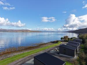 a house on the shore of a body of water at Angusfield Cabins in Sconser