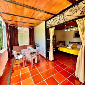 a room with a table and chairs and a bed at Hotel campestre los gabrieles in Rivera