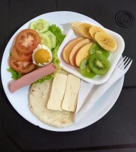 a plate of food with cheese and fruit on it at Hotel Brisas MEDELLIN in Medellín +35 photos