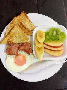 a plate of breakfast food with eggs toast and fruit at Hotel Brisas MEDELLIN in Medellín