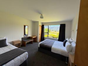 a hotel room with two beds and a window at Mt Cook View Motel - Fox Glacier in Fox Glacier