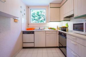 a kitchen with a sink and a microwave at Maraini Elegante Apartment with Jacuzzi & Balcony - Happy Rentals in Lugano
