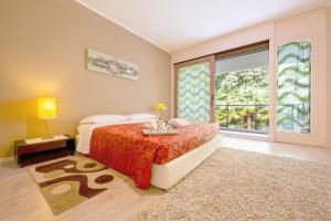 a bedroom with a bed and a large window at Maraini Elegante Apartment with Jacuzzi & Balcony - Happy Rentals in Lugano