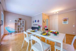 a dining room with a white table and chairs at Maraini Elegante Apartment with Jacuzzi & Balcony - Happy Rentals in Lugano +16 photos