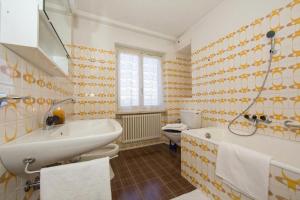 a bathroom with a sink and a tub and a toilet at Chalet Cademario Lake-View 3BR Duplex - Happy Rentals in Cademario