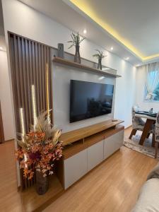 a living room with a flat screen tv on a wall at Apartamento completo e confortável em Duque de Caxias in Duque de Caxias
