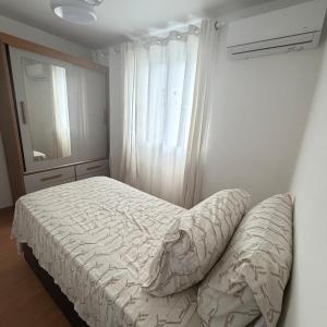 a bedroom with a bed and a window and a mirror at Apartamento completo e confortável em Duque de Caxias in Duque de Caxias +11 photos