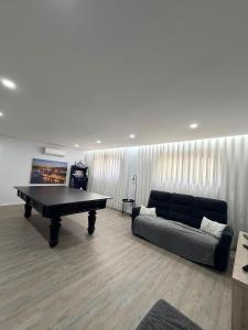 a living room with a ping pong table and a couch at Dream House in Aldeia Nova
