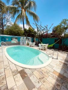 a small pool with chairs and a palm tree at Pousada Inn Blue Horizon in Porto De Galinhas